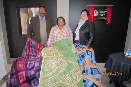 Vlnr is Tommy Volkwyn, Ellen Dunston en Ivy van Huyssteen tydens die oorhandiging van die warm komberse  